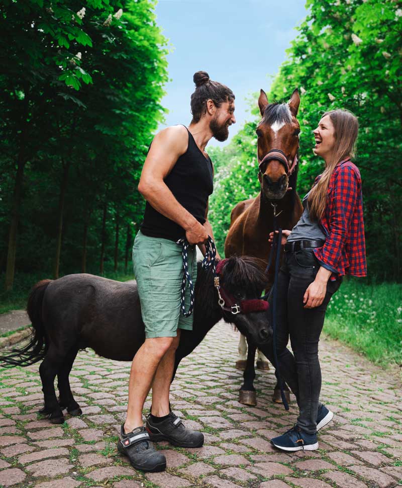 Freiwilliges Engagement auf dem NaturGut schwarzer Hund liegt auf roten Yogamatten für das Familien-Yoga. Matten liegen im Gras und die Sonne scheint.